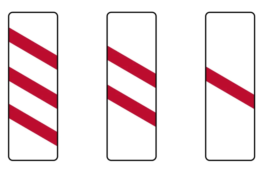 On UK roads, red and white countdown markers are used to give drivers advance warning of a level crossing — where a road meets a railway line.