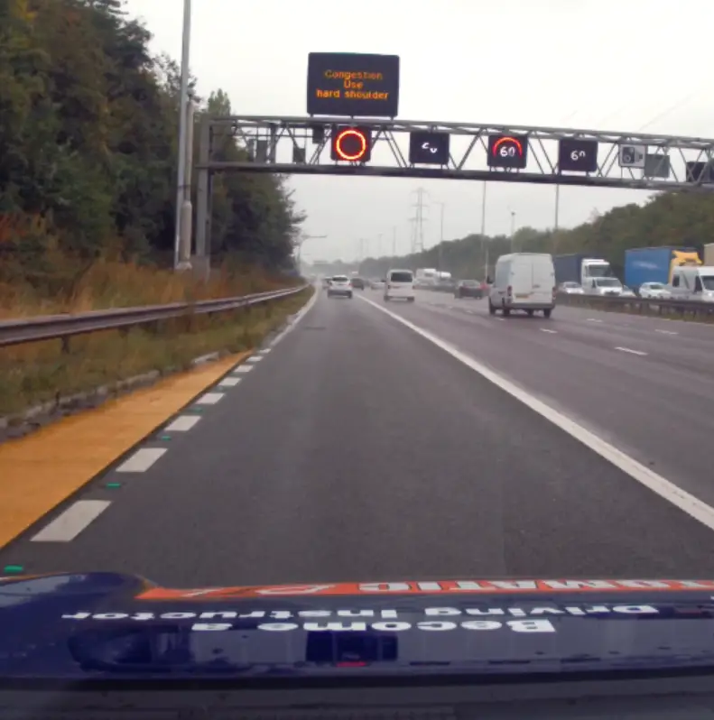 When directed by police or National Highways officers.
During roadworks, if temporary signs instruct you to use the hard shoulder.
On smart motorways, when overhead gantry signs display a speed limit above the lane and show it is open for use.