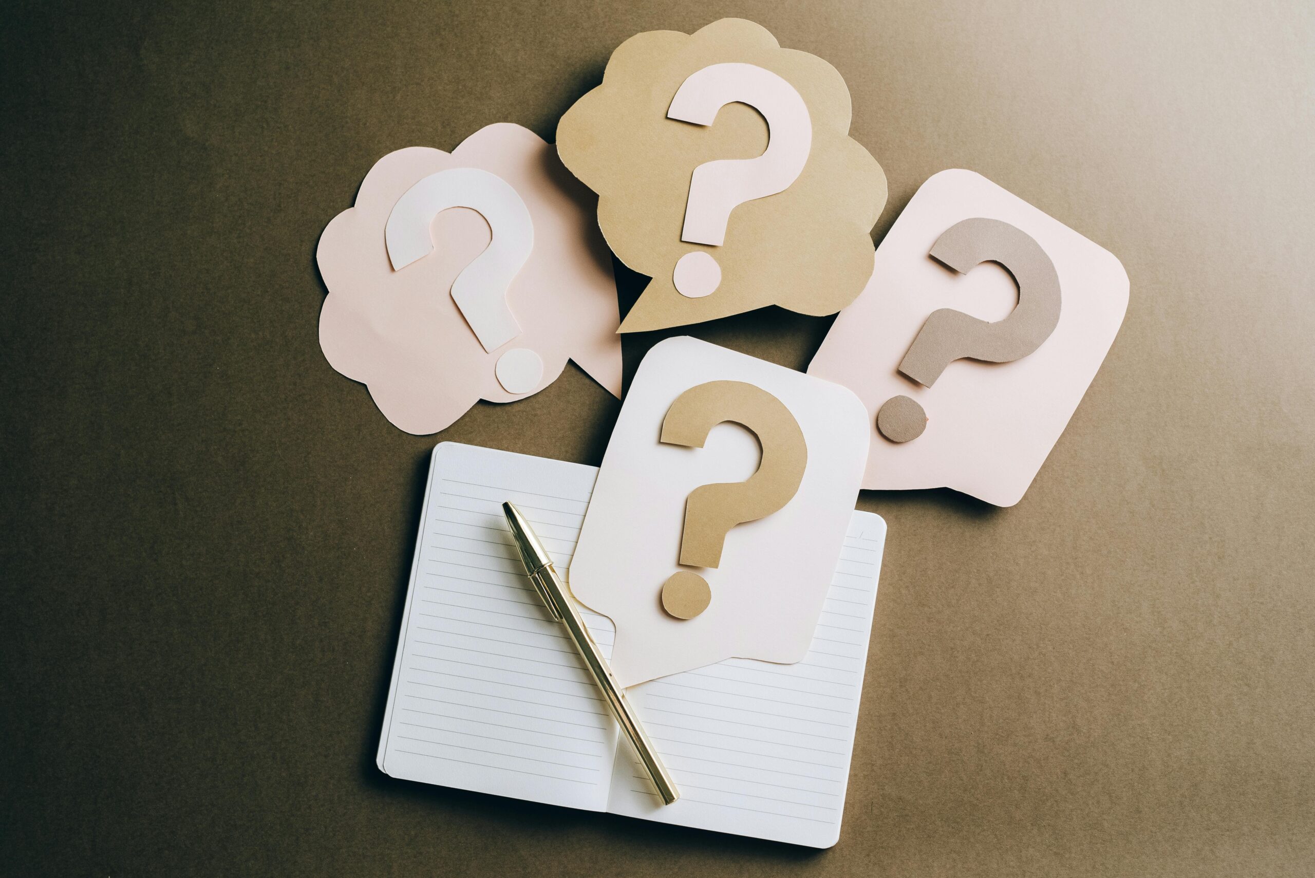 Three paper speech bubbles with question marks